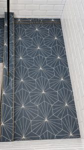 Blue geometric shower floor with brass drain