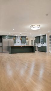 Levelled open plan kitchen with green cabinetry