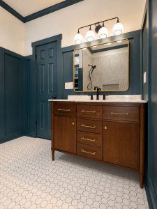 Teal bathroom vanity with gold mirror